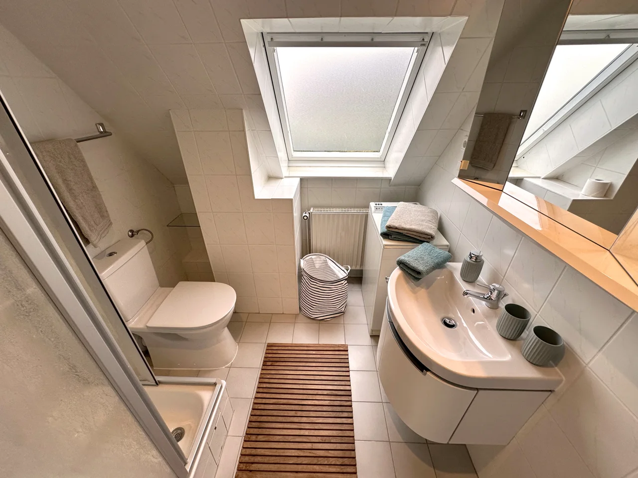 Badezimmer mit Dusche, Waschbecken, WC und Dachfenster