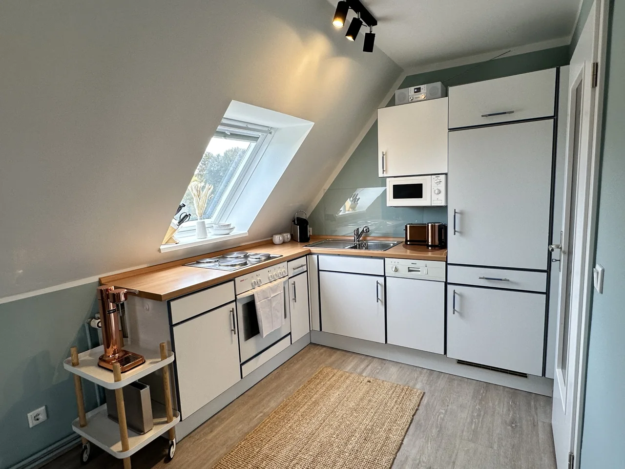 Voll ausgestattete Küche mit Geschirrspüler, Backofen und Kühlschrank